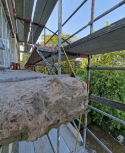 Fachmännische Betonsanierung an einem Mehrfamilienwohnhaus durchgeführt von Malerbetrieb Rickers, Wiederherstellung der Stabilität und Ästhetik der Betonstrukturen.